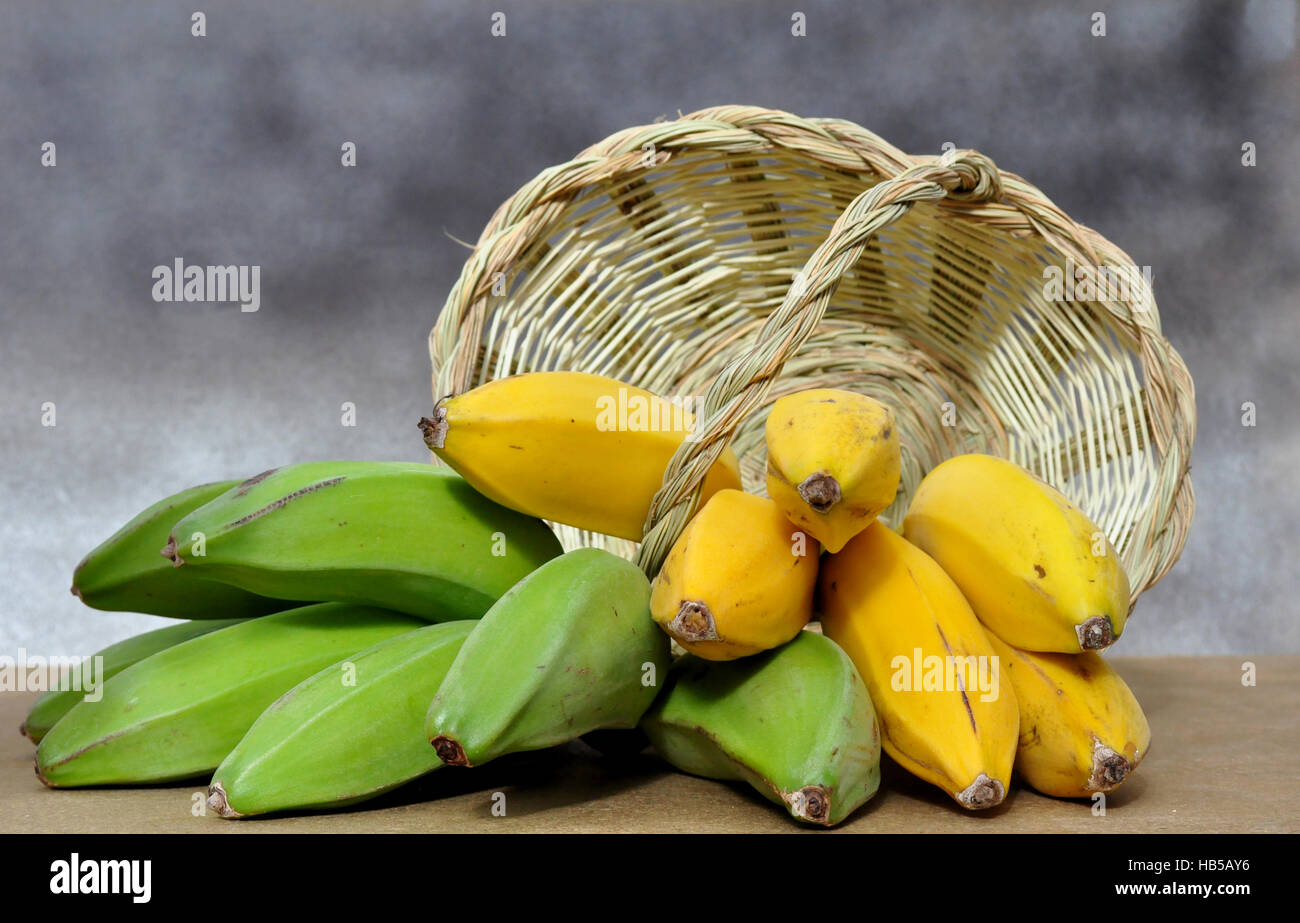 Plátano verde y amarillo en la canasta Foto de stock