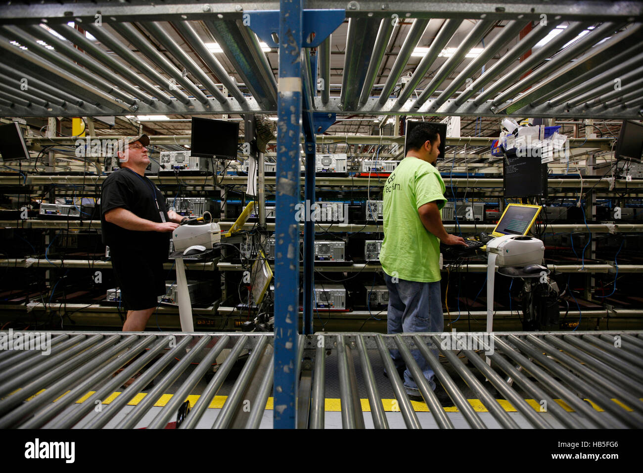 Los trabajadores comprobar discos duros antiguos en Tech vuelta, una empresa de reciclaje del equipo. Foto de stock
