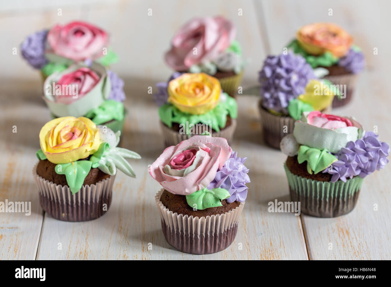 Cupcakes de chocolate con flores de color crema. Foto de stock