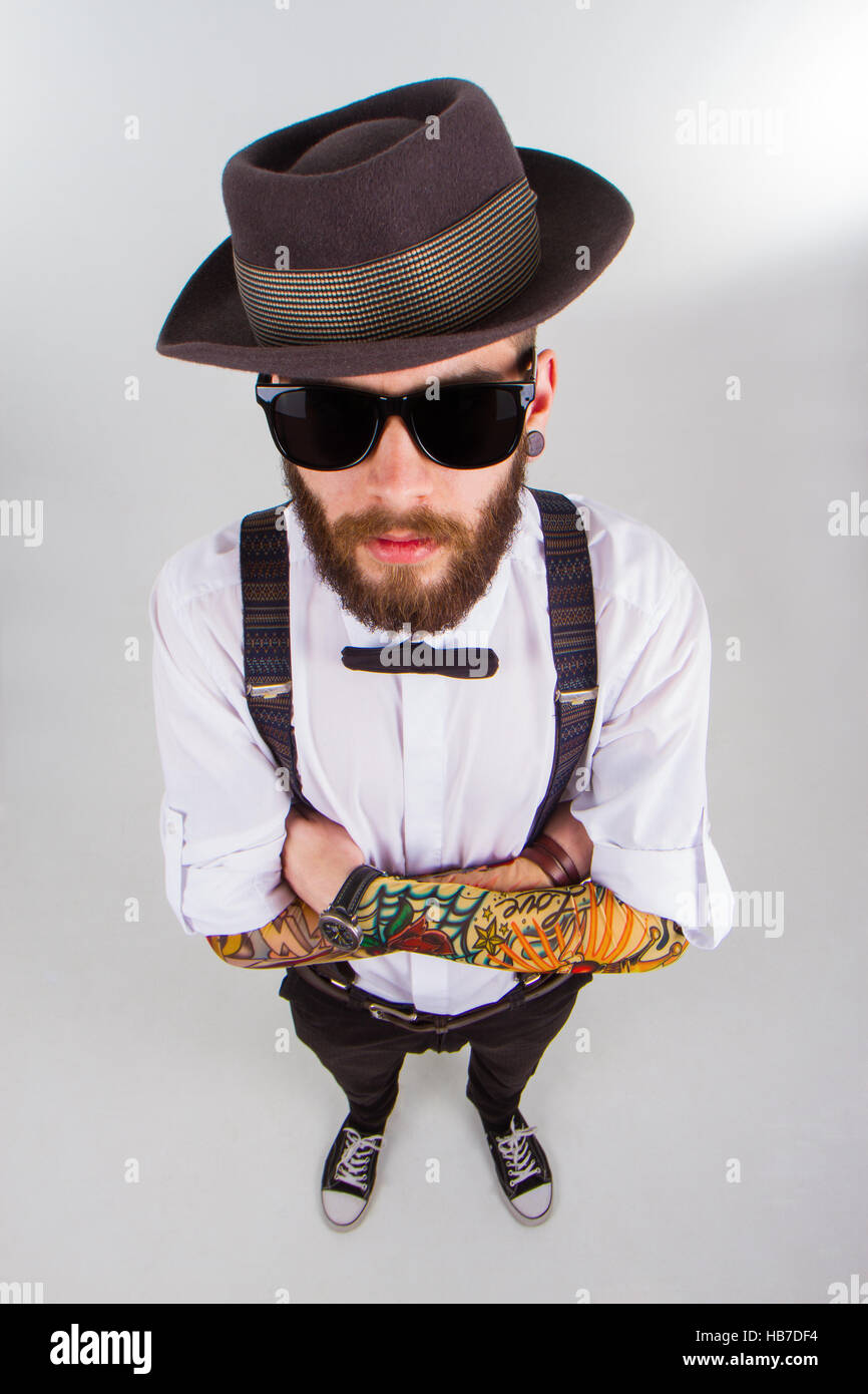 Young hipster hombre vestido sombrero , tirantes , pajarita y un gracioso Fotografía de stock - Alamy