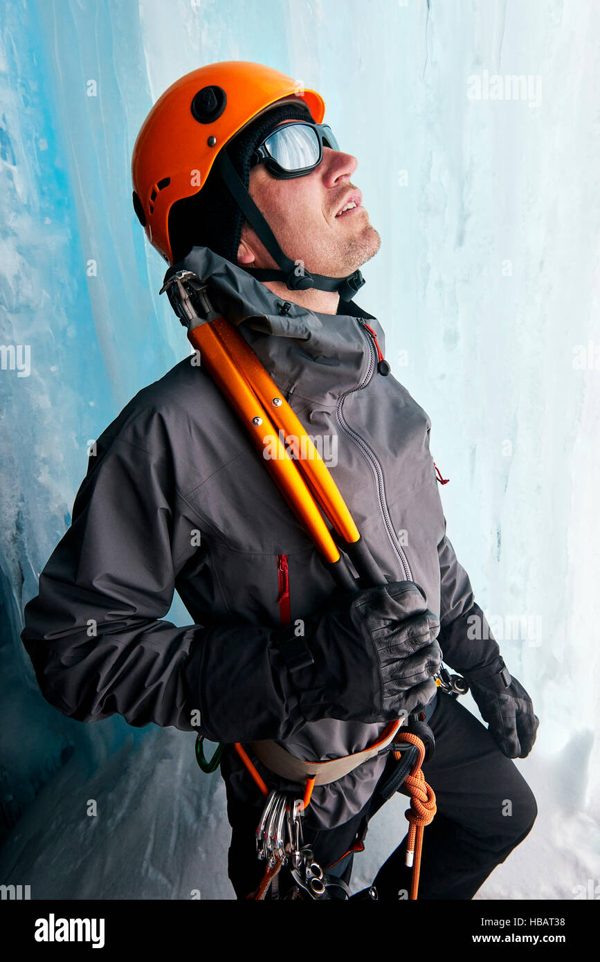 Retrato de escalador de hielo en la cueva de hielo mirando hacia arriba Foto de stock