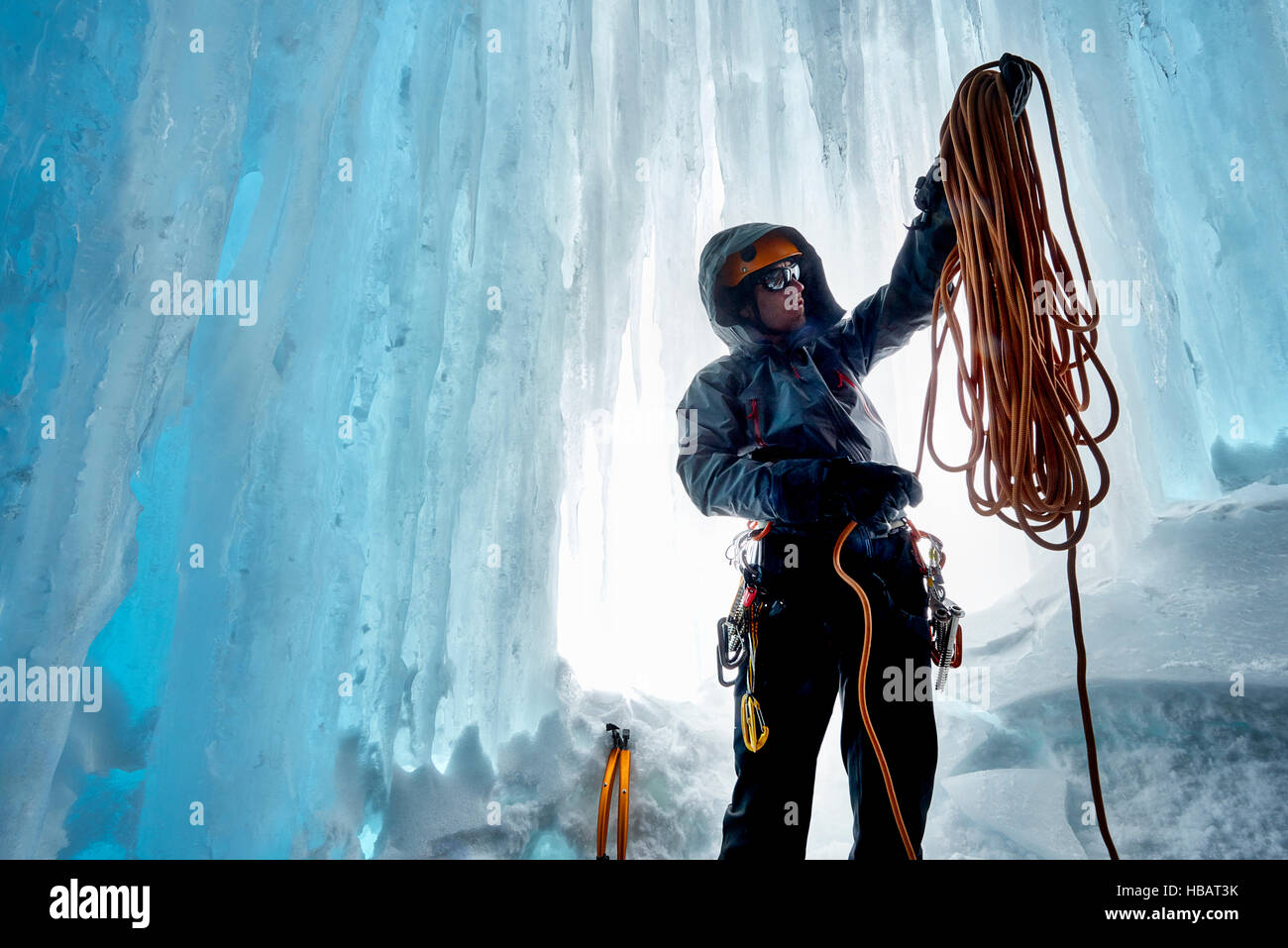 El hombre en la cueva de hielo preparando la cuerda de escalada, Saas Fee, Suiza Foto de stock