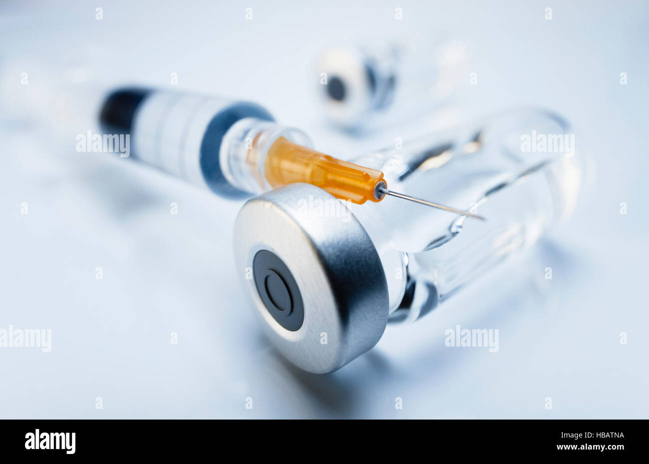 Medicamentos inyectables en frascos herméticamente cerrados y una jeringa de plástico desechable médica Foto de stock