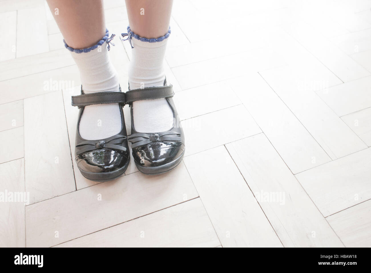 Captura recortada de colegiala llevar zapatos y calcetines de tobillo pie  sobre suelo de parquet Fotografía de stock - Alamy