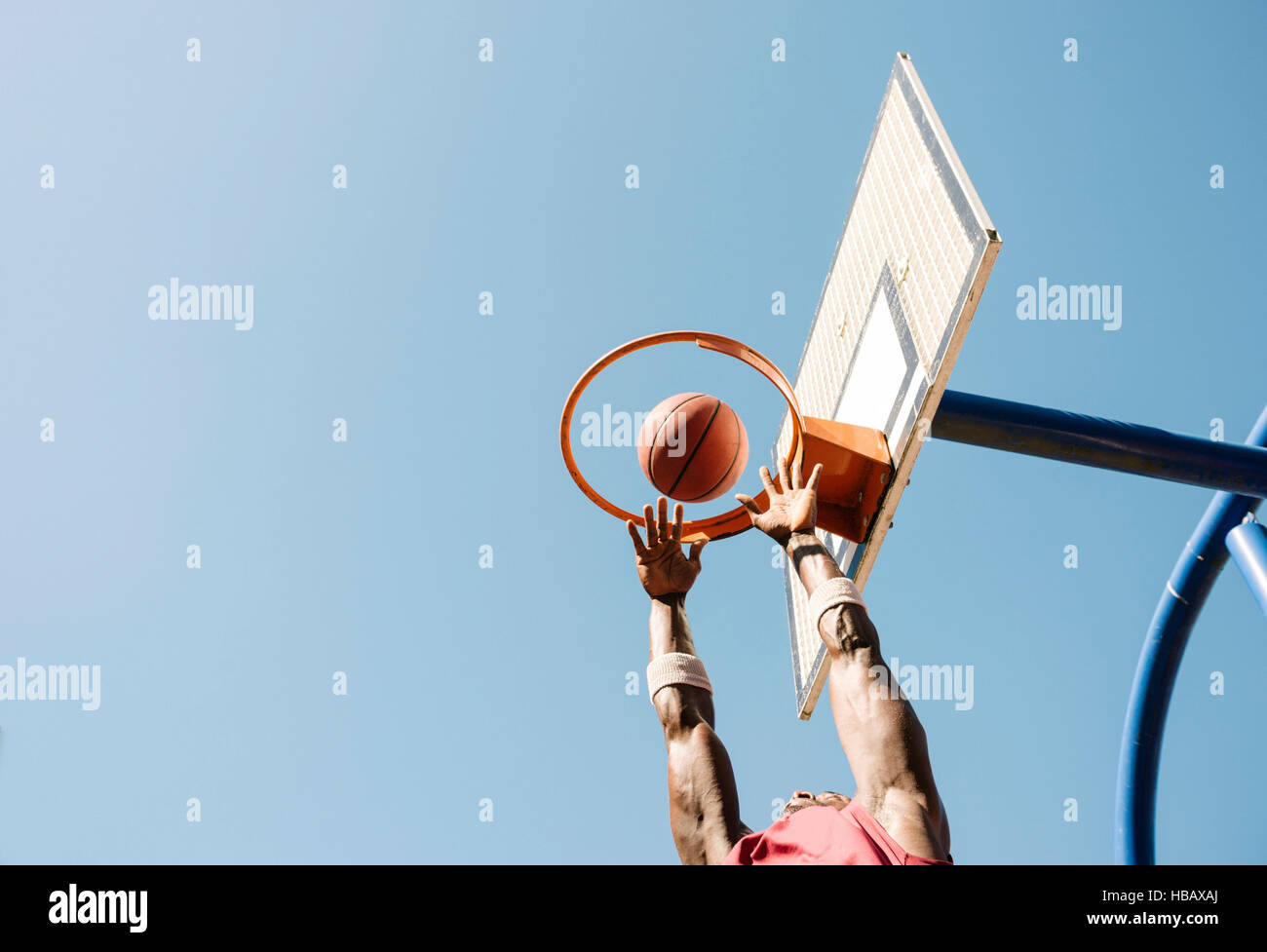 Joven jugador de baloncesto masculino lanzando la bola de baloncesto Foto de stock