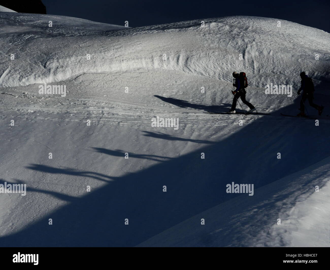 Dos alpinistas caminando sobre la nieve Foto de stock