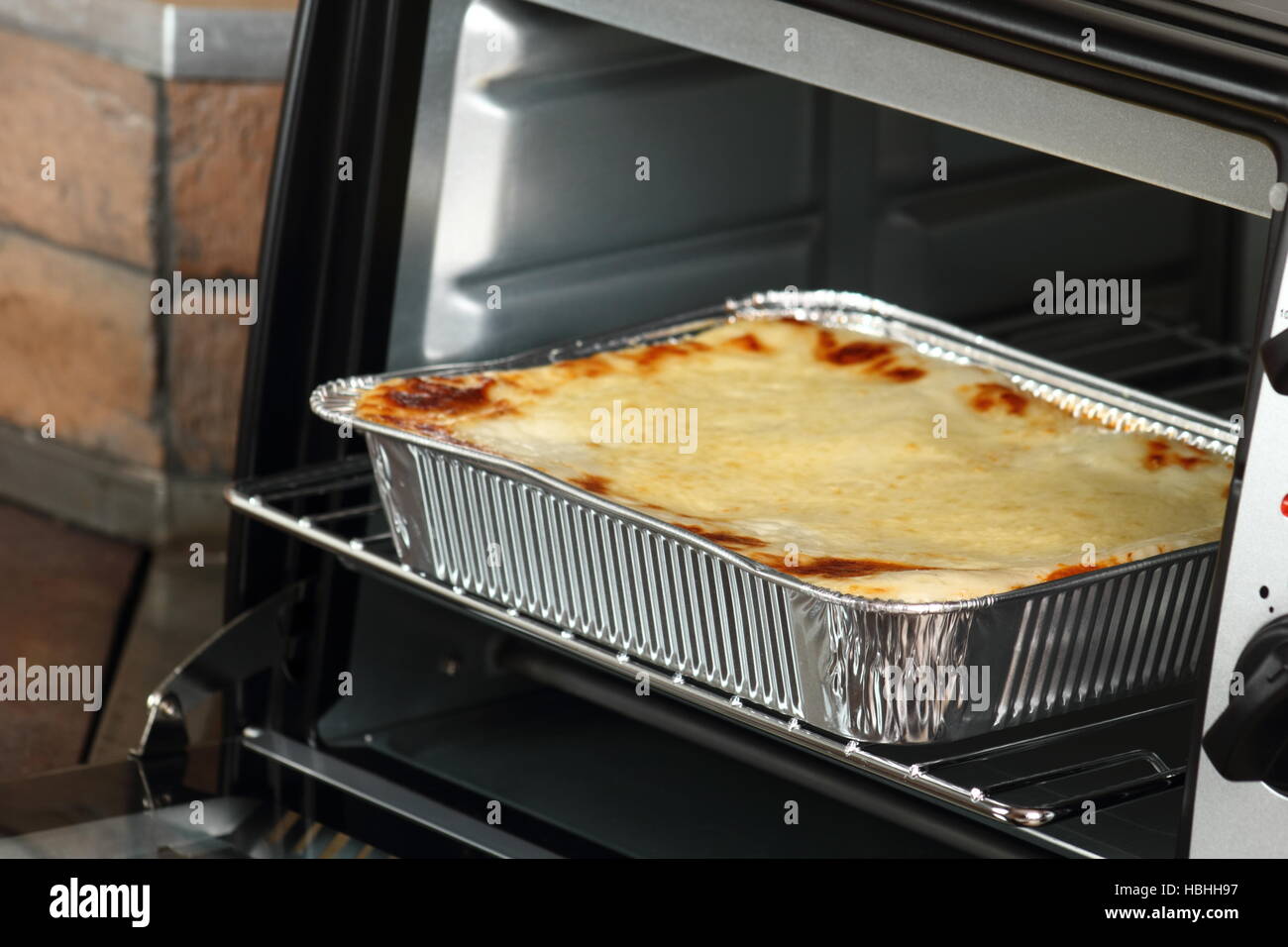 Hornear la Lasaña a la Boloñesa en desechables, un plato de aluminio en horno  eléctrico Fotografía de stock - Alamy