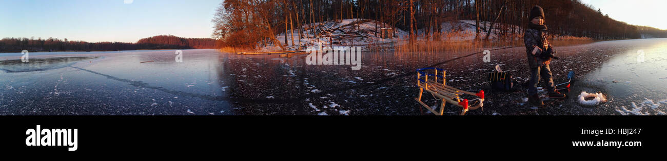 Pescar en el hielo en el ocaso Foto de stock