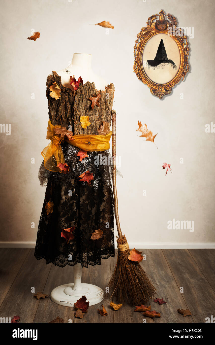 Maniqui vestidos para el otoño con la escoba de bruja y sombrero en el marco de imagen en la pared Foto de stock