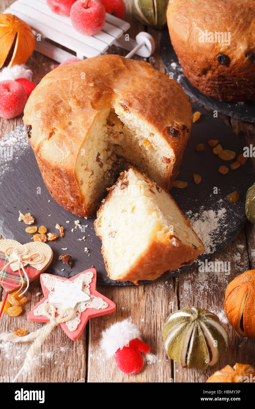 Panettone pan casero con frutos secos y decoraciones de Navidad de cerca en la tabla vertical. Foto de stock