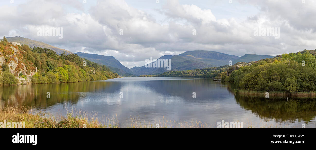Llyn Padarn lago cerca de la aldea de Llanberis y el Macizo de Snowdon distantes, el Parque Nacional de Snowdonia, Gwynedd, North Wales, REINO UNIDO Foto de stock