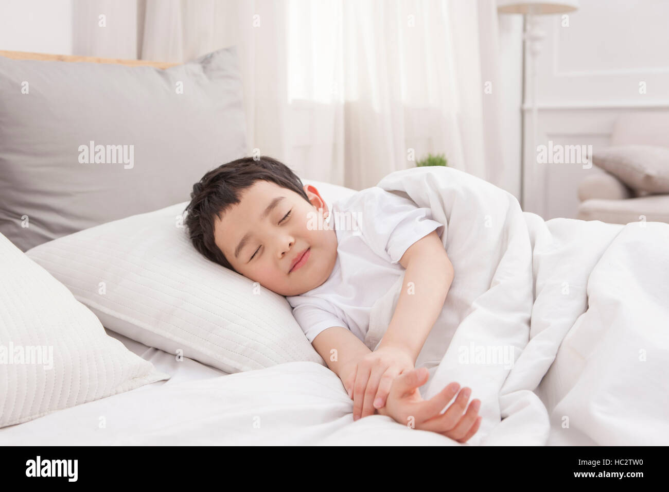 Chico coreano durmiendo en cama Fotografía de stock - Alamy