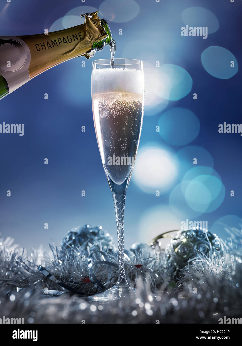 Flauta de champagne con burbujas de oro sobre fondo bokeh de luz azul  oscuro Fotografía de stock - Alamy