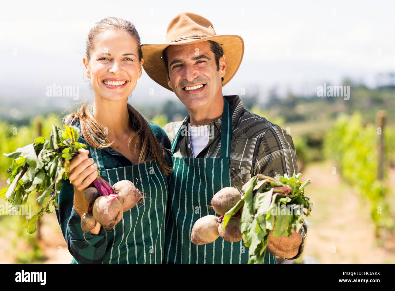 Retrato de feliz agricultor par la celebración de verduras Foto de stock