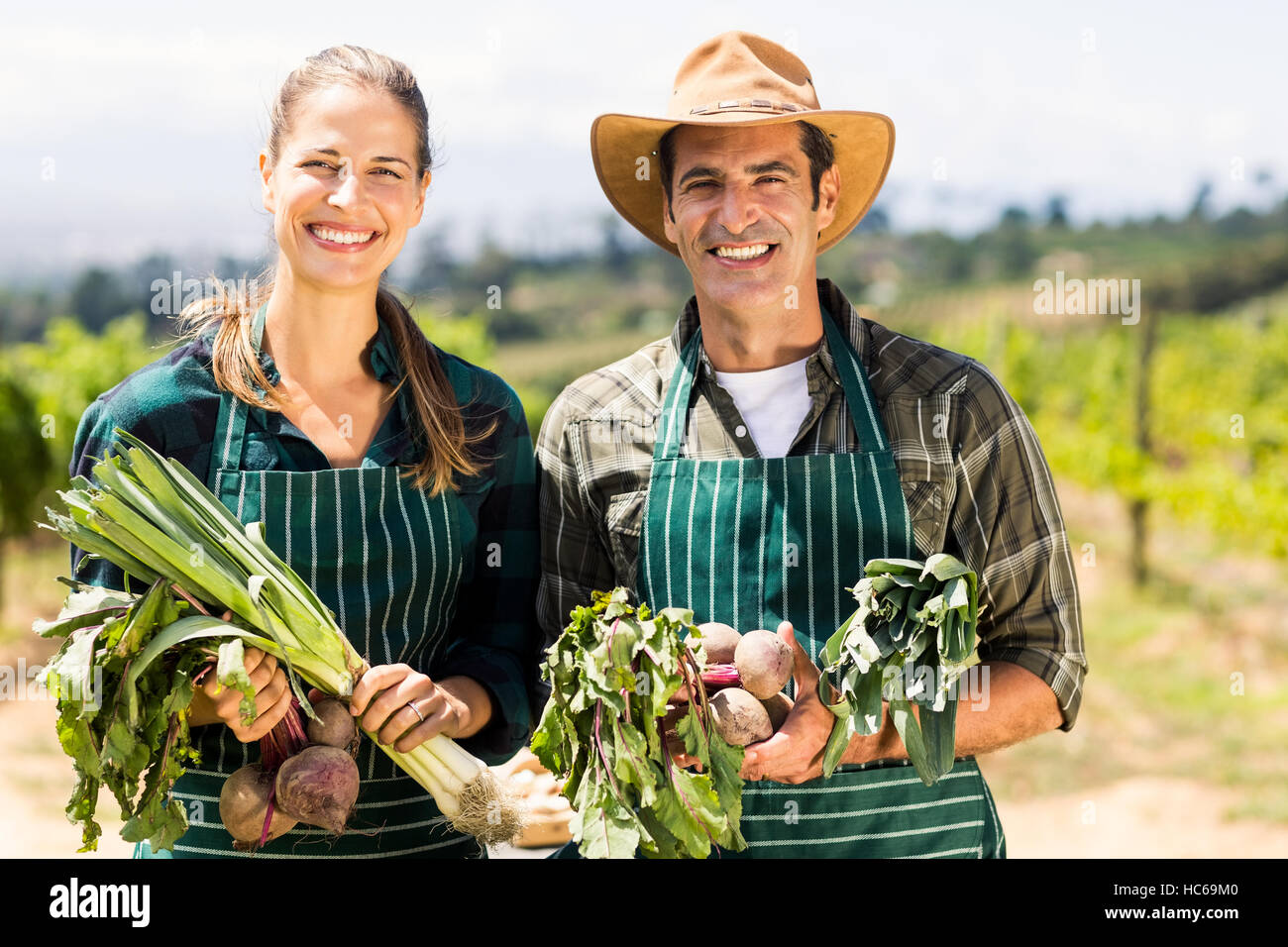 Retrato de feliz agricultor par la celebración de verduras Foto de stock