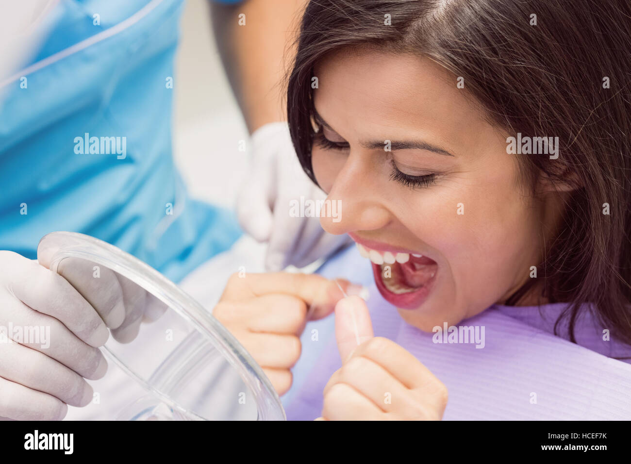 Paciente de sexo femenino, el uso de hilo dental sus dientes Fotografía de  stock - Alamy