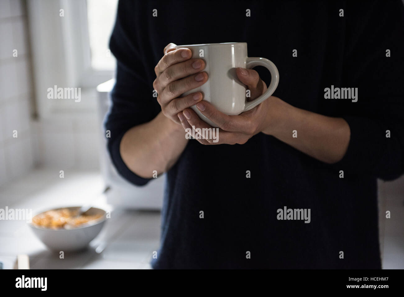 Hombre sujetando una taza de café negro en casa Foto de stock