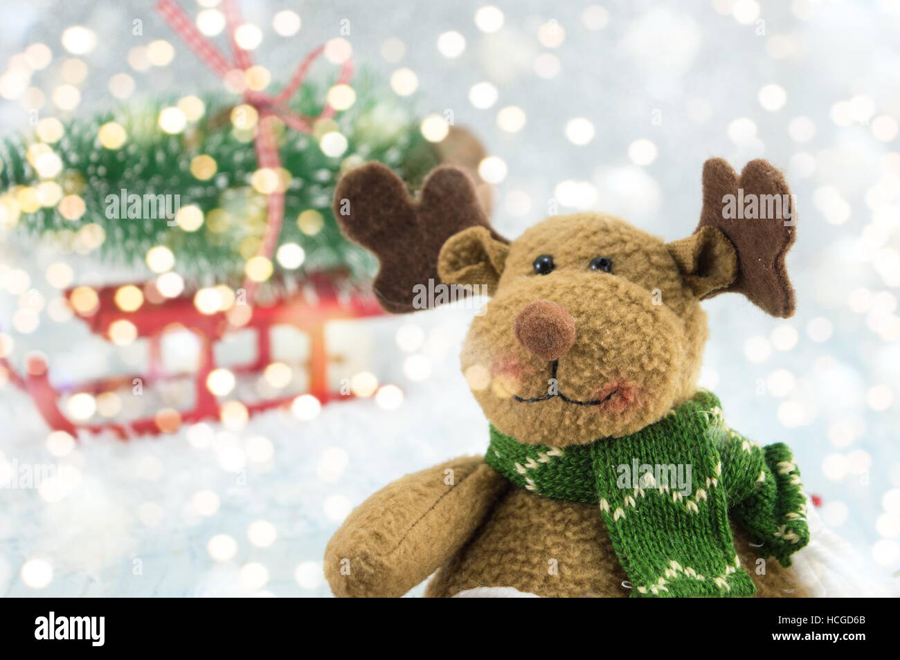 Renos de juguete y un árbol de navidad en trineos cubierto con nieve Foto de stock