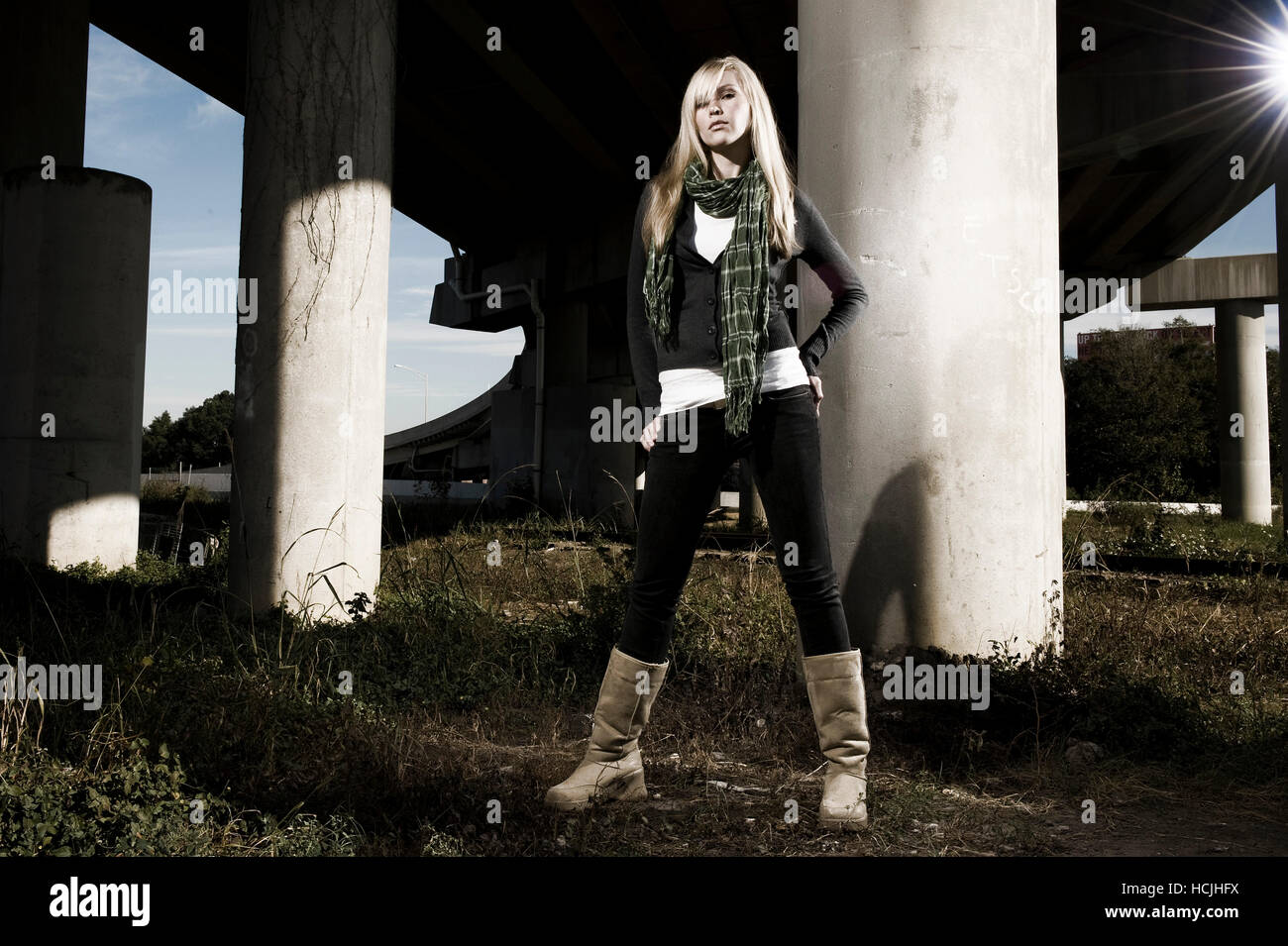 Una mujer rubia alta lleva botas altas, pantalón negro y una bufanda bajo y  elevado Fotografía de stock - Alamy