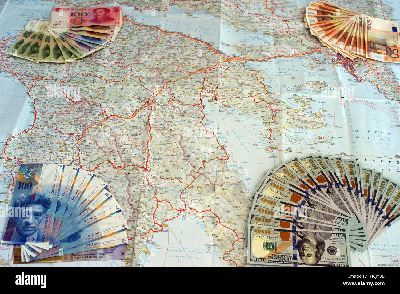 Euro, yuan, dólares y franco suiza billetes en el mapa de Grecia. Simbolizan la moratoria griega y de los intereses extranjeros. Foto de stock