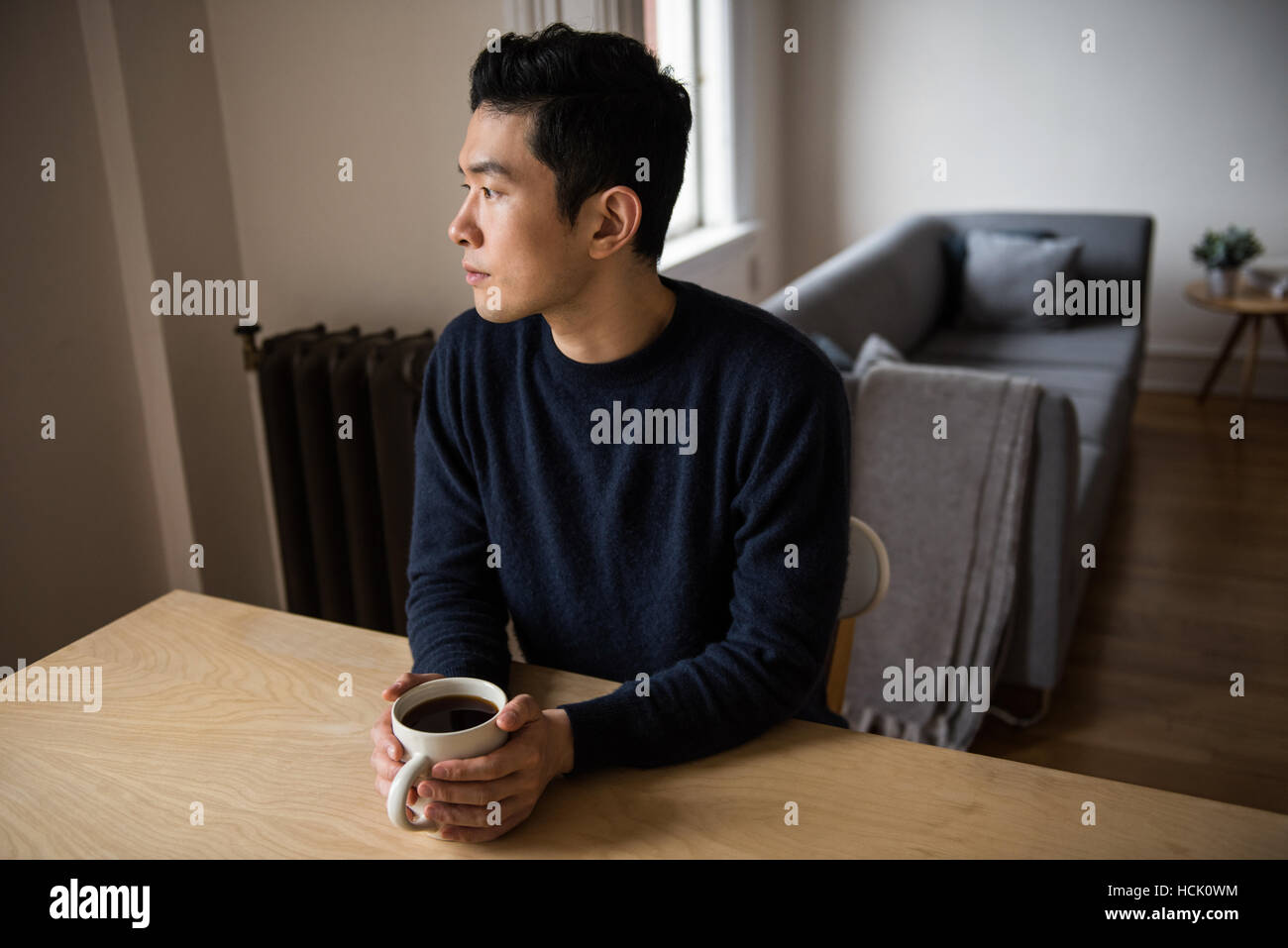 Pensativo hombre sujetando una taza de café negro Foto de stock