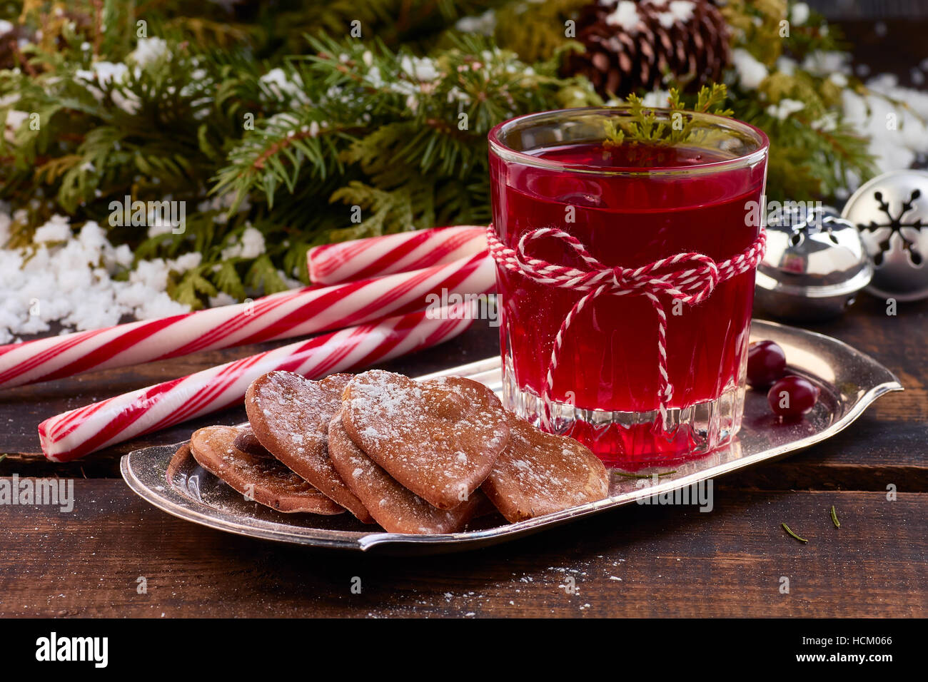 Vaso de bebidas de frutas de arándano y ginger cookies en placa metálica por mesa de madera antigua. Foto de stock