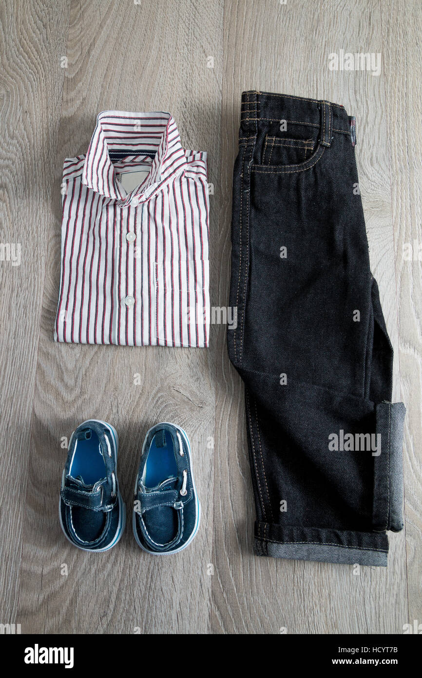 Chico traje. Camisa a rayas, pantalones de mezclilla y zapatos en azul  sobre fondo de madera gris Fotografía de stock - Alamy