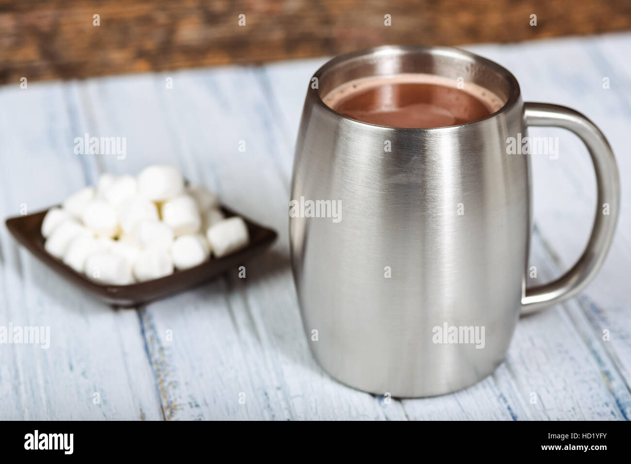 Chocolate caliente o el capuchino en una jarra de acero inoxidable plateado. Foto de stock