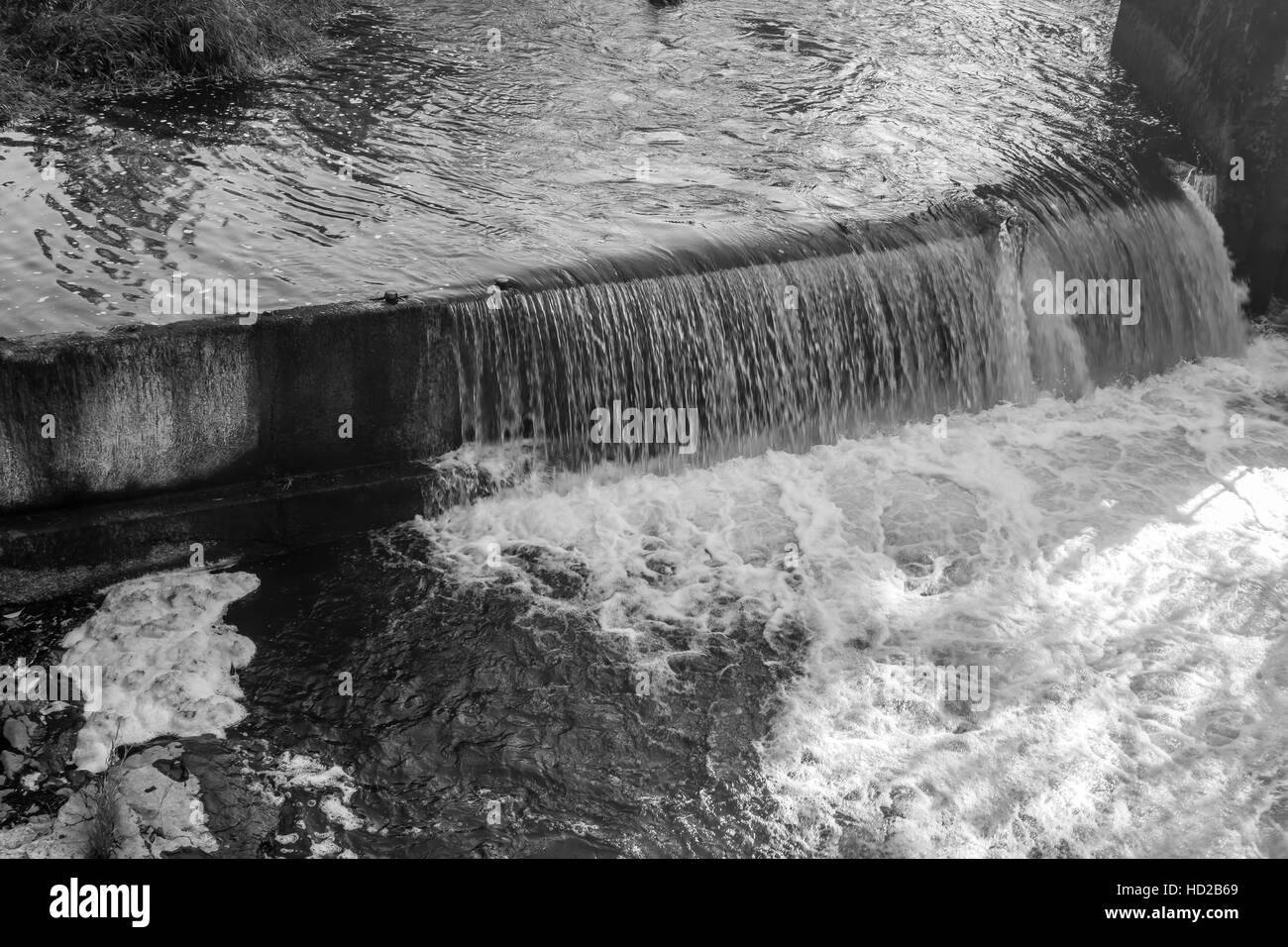 Agua fluyendo en Tumwater Falls crea una cortina brillante. Imagen en blanco y negro. Foto de stock