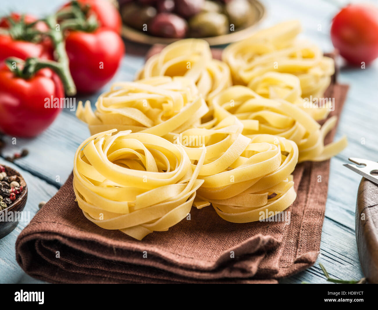 Pasta ingredientes. Tomates Cherry, spaghetti pasta y especias sobre la mesa de madera. Foto de stock