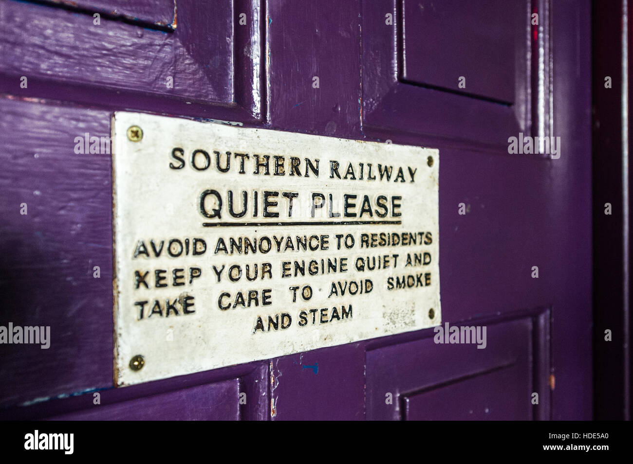 Señal de Southern Railway 'Quiet Please' en una puerta púrpura. Foto de stock