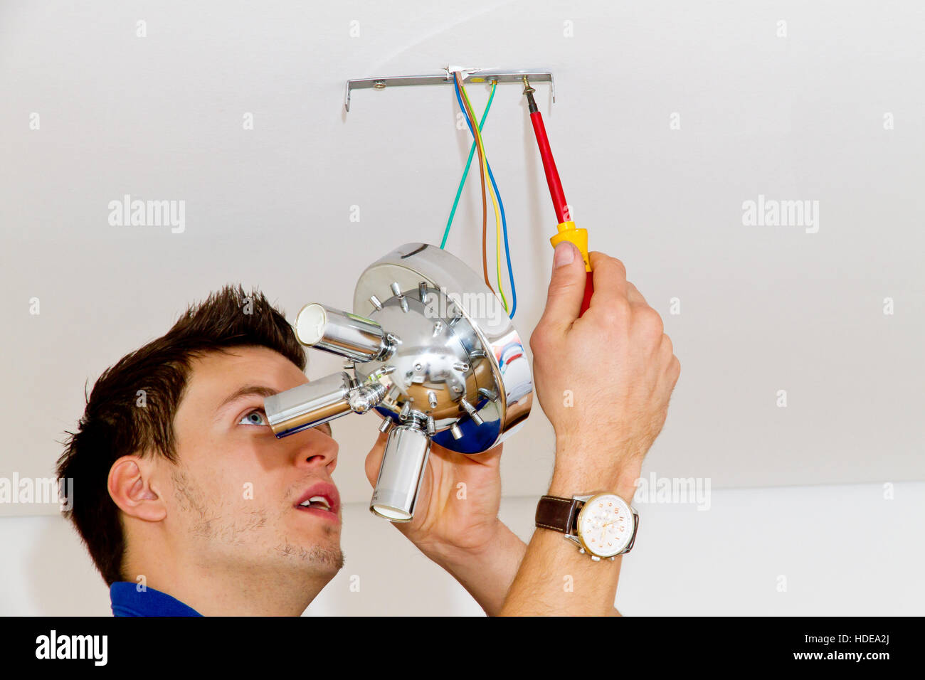 Retrato de electricista de la instalación de una nueva lámpara en casa Foto de stock