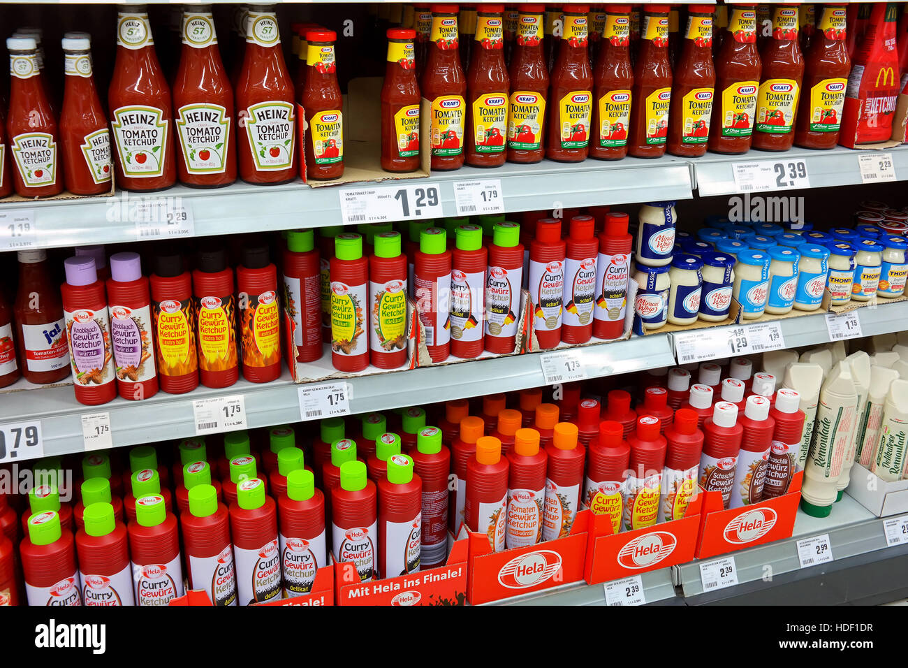 Los estantes con una gama diferente de ketchup productos en un supermercado REWE Foto de stock
