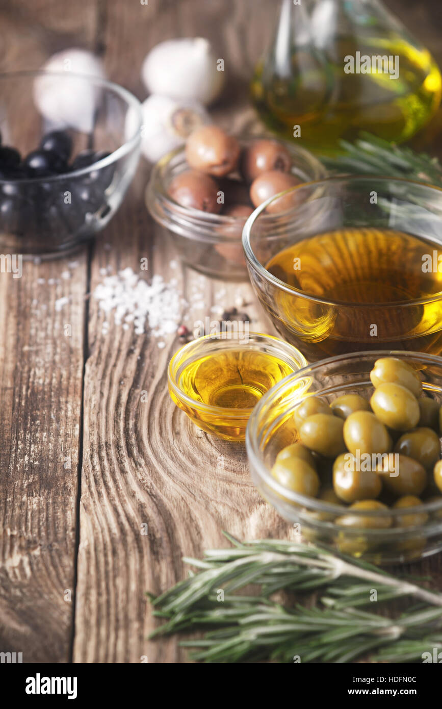 El aceite de oliva y las aceitunas en la mesa de madera Foto de stock