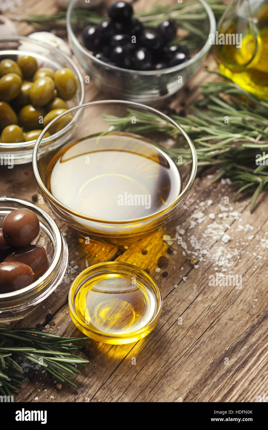 El aceite de oliva con aceitunas mezclar en la mesa de madera vertical Foto de stock