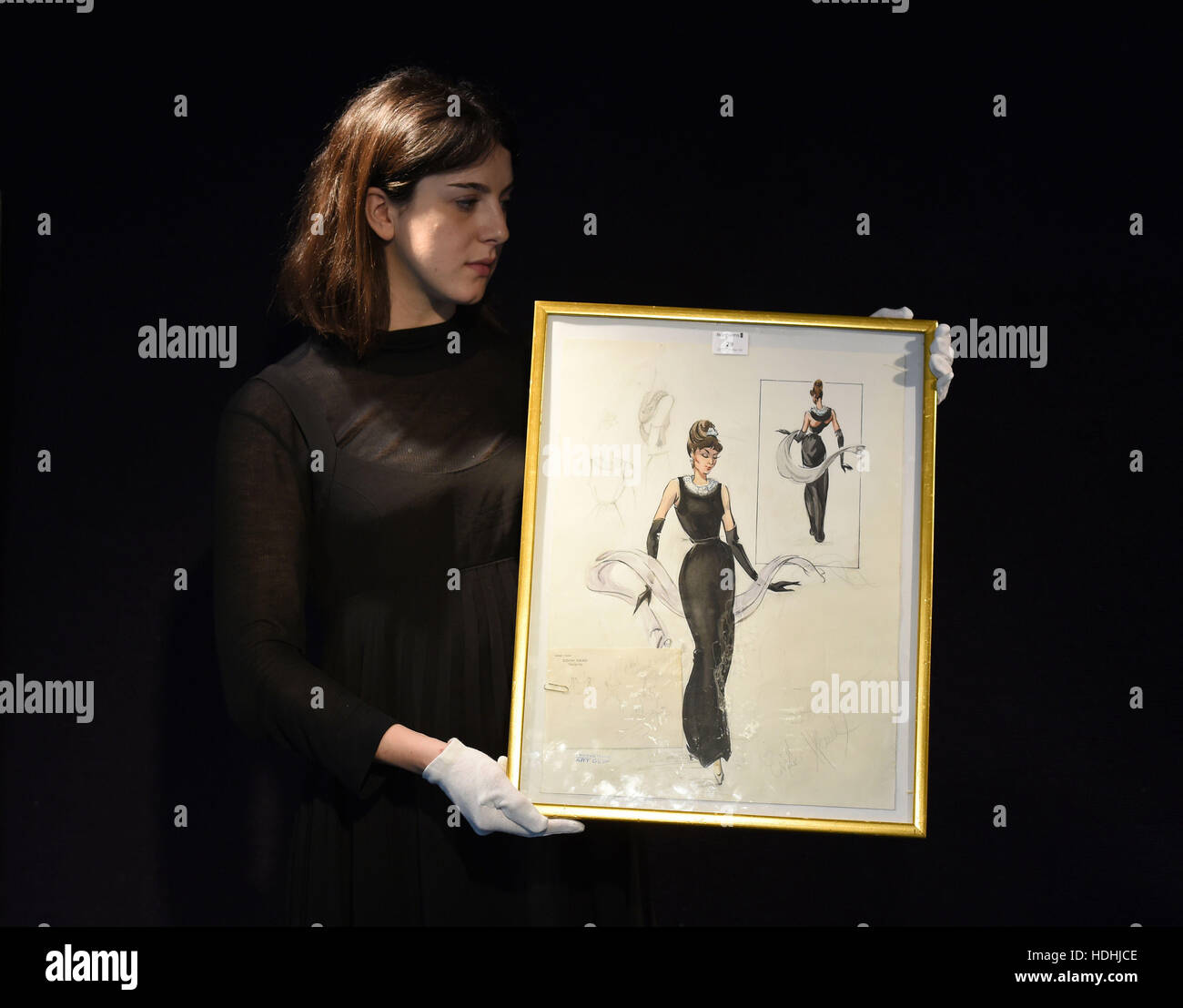 Un miembro del personal tiene un dibujo a lápiz y acuarela de Audrey Hepburn vestida como Holly Golightly en desayuno en Tiffany en la pantalla antes de la venta de recuerdos del entretenimiento en Bonhams en Knightsbridge, Londres esta semana. Foto de stock