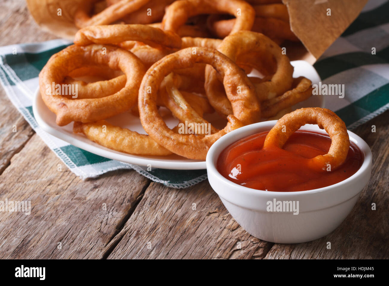 Aros de cebolla frita y ketchup closeup. horizontal sobre la tabla antigua Foto de stock