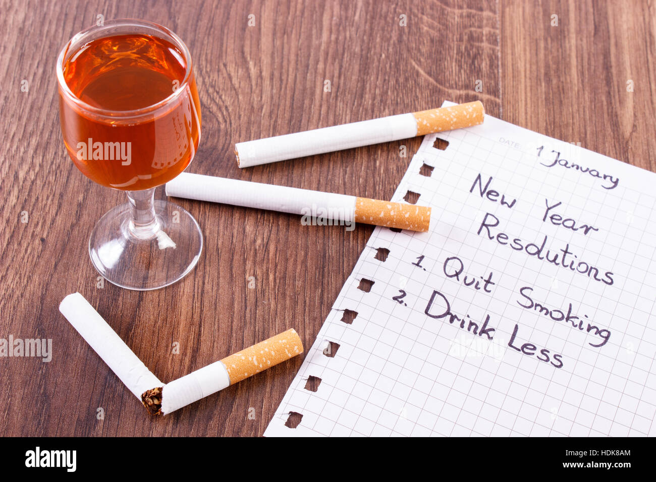 Resoluciones de año nuevo, dejar de fumar y beber menos escrita en hoja de  papel roto y cigarrillo con una copa de vino, el concepto de estilo de vida  saludable Fotografía de