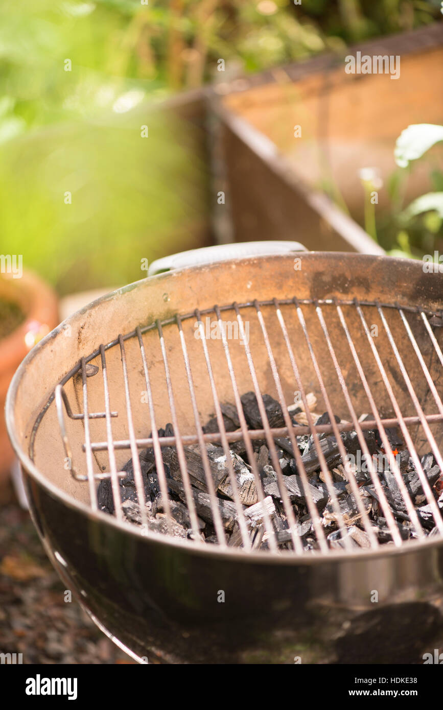Preparación de barbacoa en el jardín con el carbón en la parrilla. Cocina de verano al aire libre. Foto de stock