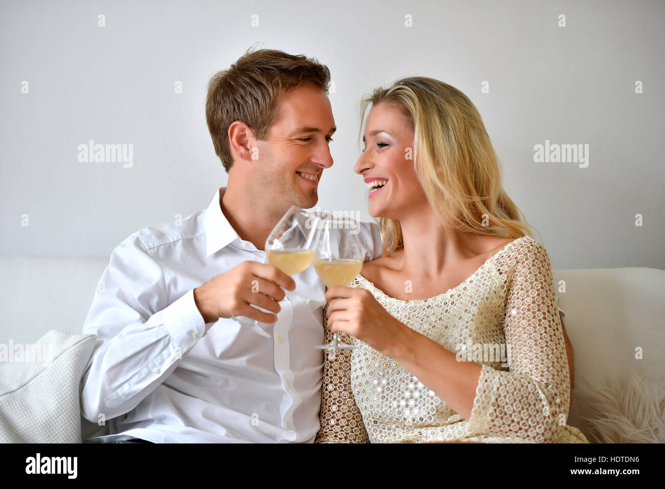 Hombre, Mujer, pareja en el sofá, en el amor, el vino, el vidrio contiguos Foto de stock