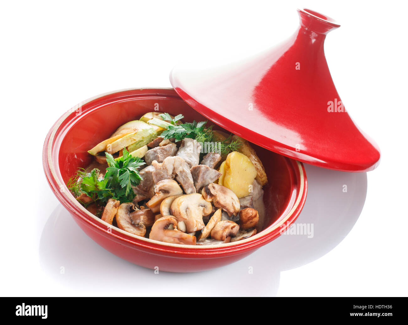 Guiso de verduras con carne, hongos y hierbas sobre un fondo blanco. Foto de stock