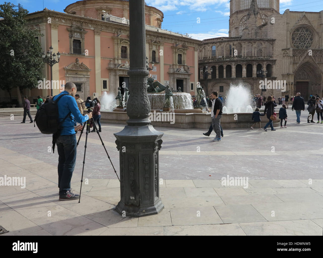 Fotógrafo que fija un trípode y una cámara para fotografiar a turistas en la Fuente de Turia en la Plaza de la Virgen, Valencia, España Foto de stock