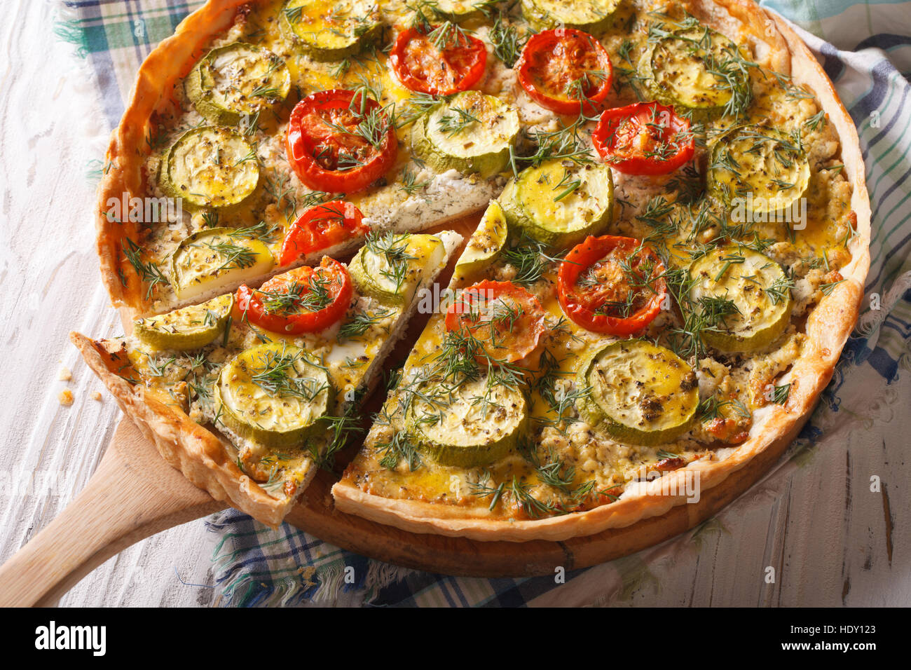 Quiche de verduras en rodajas casera con queso, tomate y calabacín en primer plano horizontal. Foto de stock