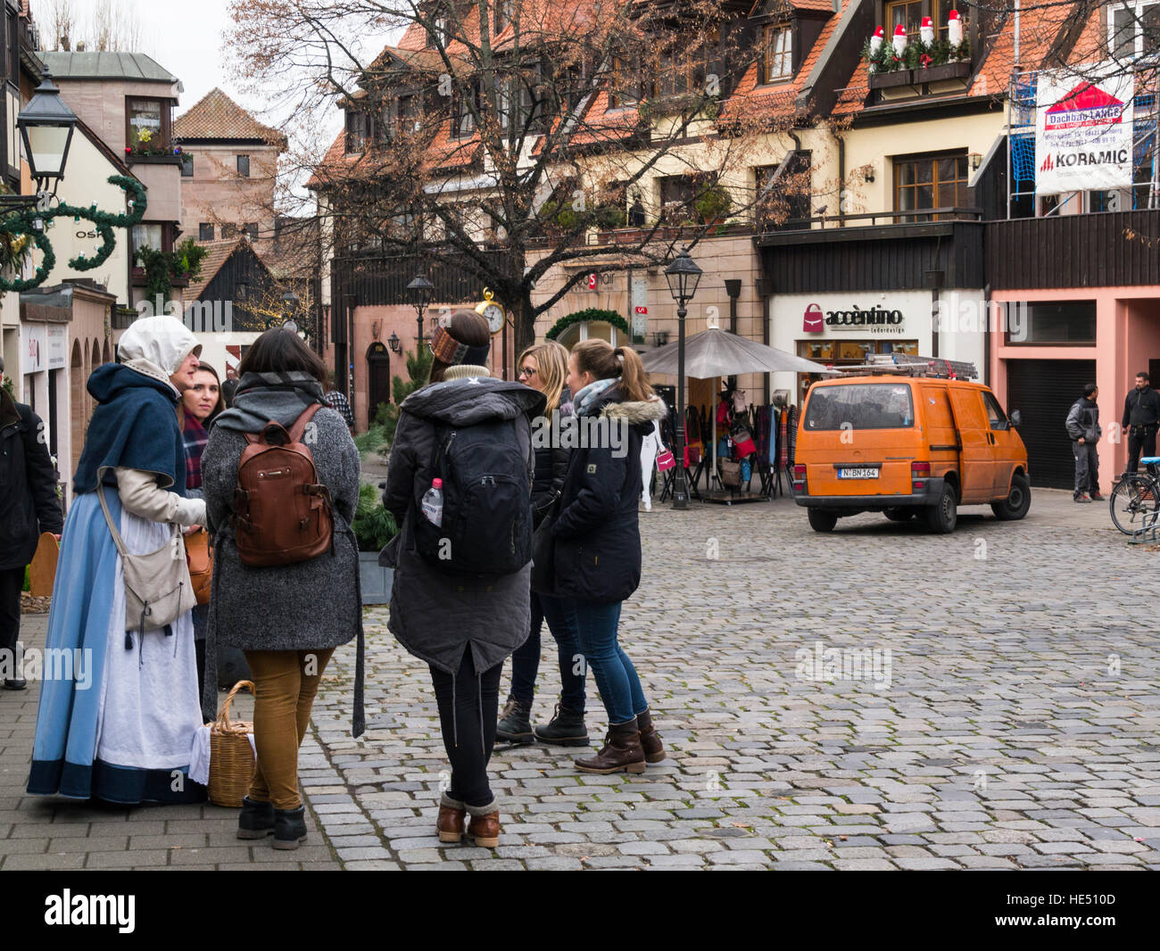 Los visitantes hablando a la mujer con la vestimenta tradicional Trodelmarkt Nuremberg Baviera Alemania UE Foto de stock