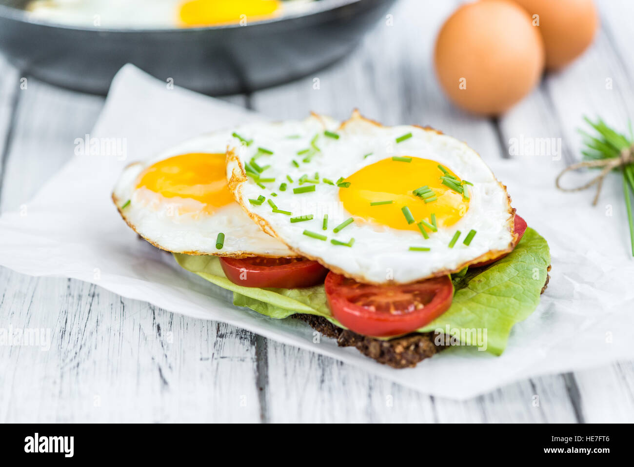 Mesa de madera con huevos fritos (en un sándwich) como primer plano detallado Foto de stock