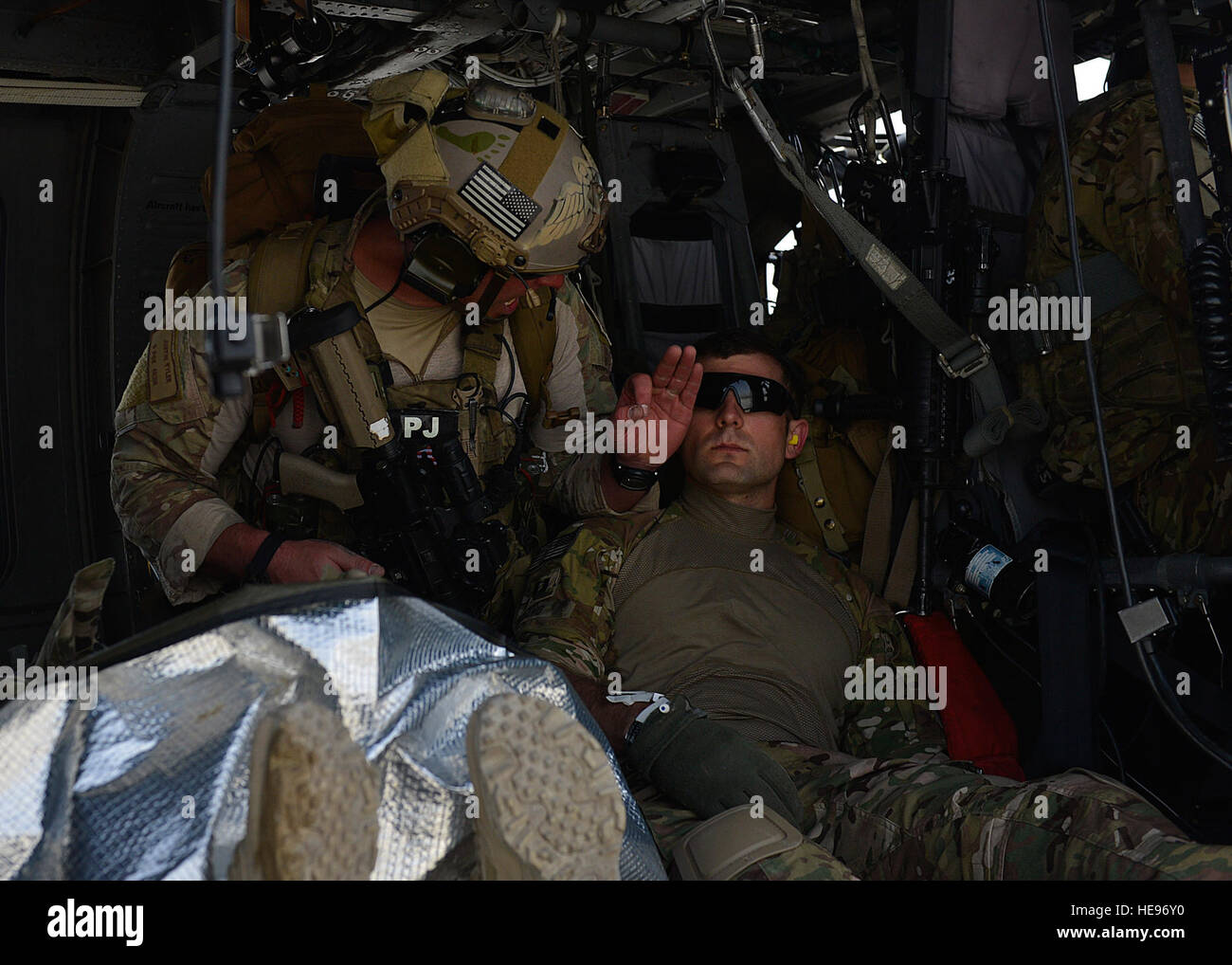El Sargento de la Fuerza Aérea de EE.UU. Justin Tyler, 83º Escuadrón de Rescate expedicionario, 455 ala expedicionaria aérea pararescue elemento líder, trata un siniestro simulado en un HH-60G allanar Hawk helicopter en Bagram Air Field, Afganistán, 5 de mayo de 2014. El escuadrón participó en un escenario de entrenamiento donde un vehículo llamativo simulado un dispositivo explosivo improvisado. Durante la capacitación, los equipos de rescate voló sobre HH-60G allanar halcones al punto de lesión simulada, proporcionado seguridad, pacientes tratados, preparado para viajar de forma segura, y abandonaron la zona. Tyler es un nativo de Columbia, Carolina del Sur y se despliega a partir de Foto de stock