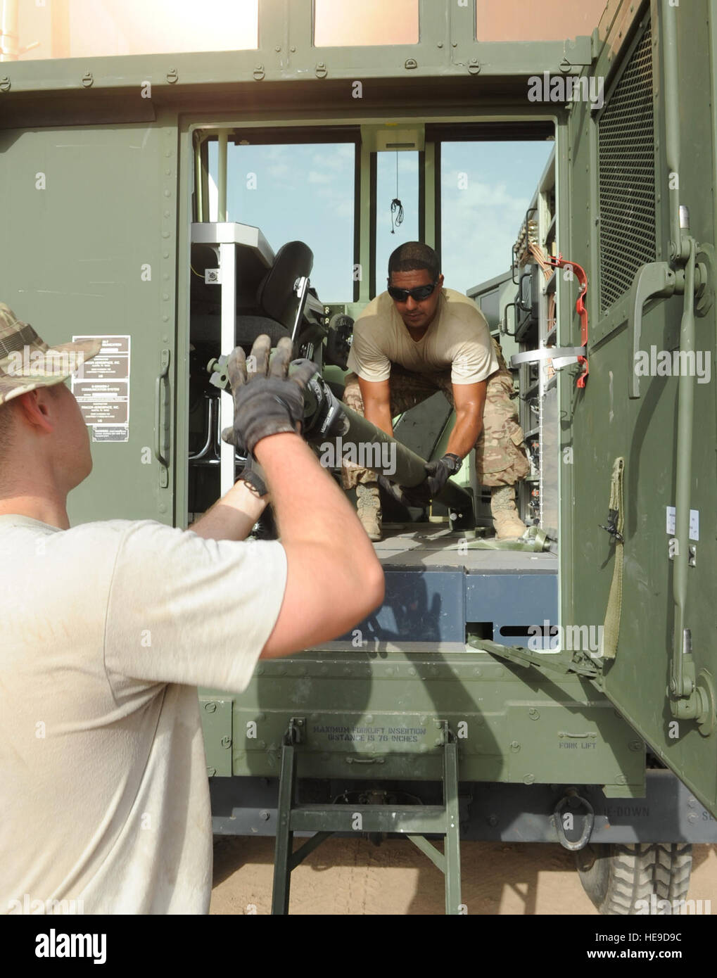 Los aviadores senior Steven Rogers, izquierda, y John Washington, primer combate escuadrón de comunicaciones del sistema de aeródromo técnicos, una antena de descarga desde el interior de un ejército Marina/móvil, tipo especial, ayuda a la navegación (AN/MSN-7), después de que fue levantado el 14 de mayo de 2013 en el campamento Lemonnier, Djibouti. El AN/MSN-7 es un móvil de la torre de control del tráfico aéreo que trae una nueva capacidad de Combined Joint Task Force-Horn de África de radar de la misión consultiva. El Sargento. Caleb Pierce) Foto de stock
