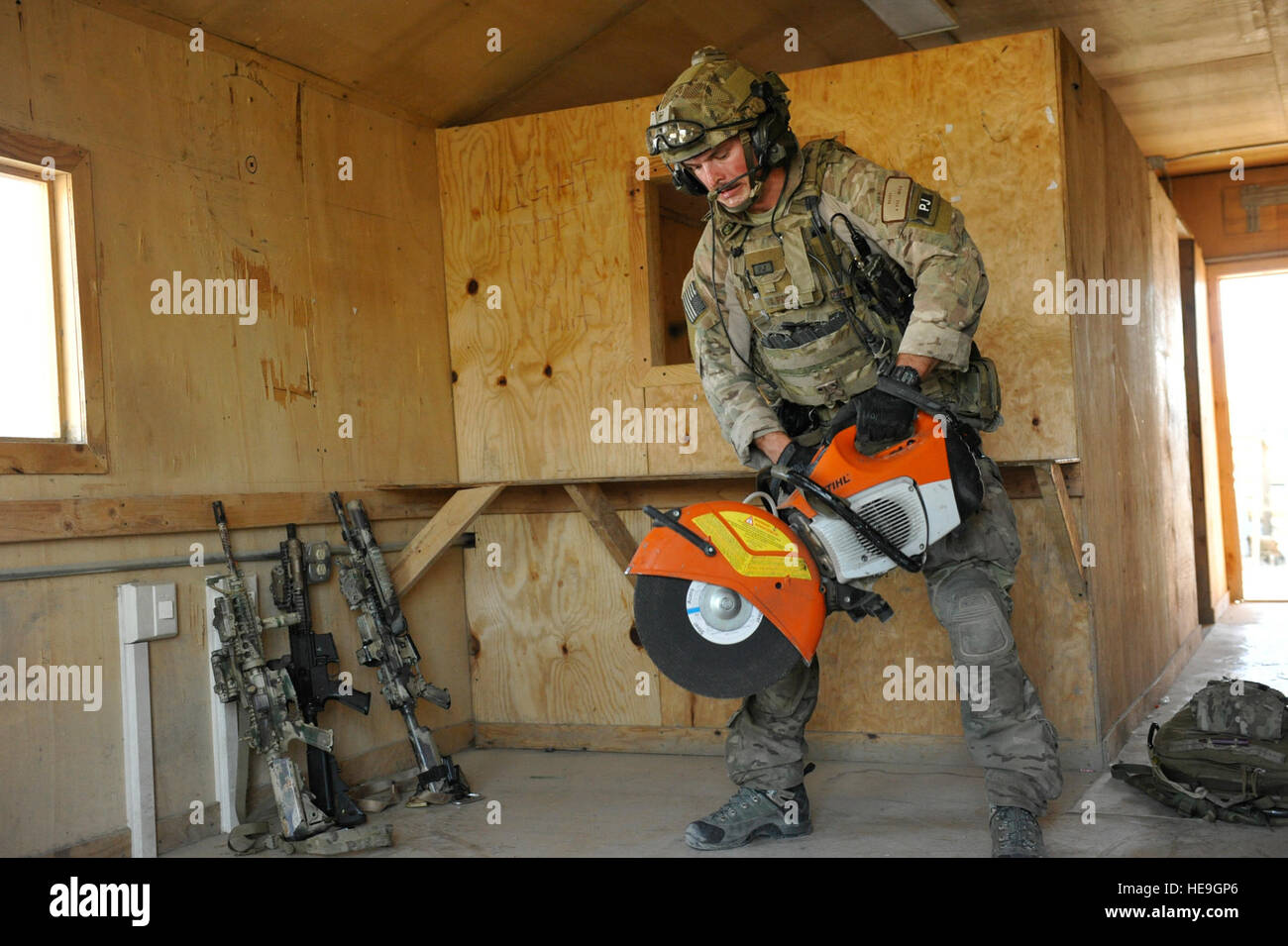 Aeródromo de Bagram, Afganistán - La Fuerza Aérea de los EE.UU Aviador Senior Joseph Brady, 83º Escuadrón de Rescate expedicionaria pararescue miembro del equipo, inicia una tronzadora durante una misión ensayo en un exceso de estructura Aquí Agosto 26, 2014. El evento permitió spj para pulir su incumplimiento, limpieza, atención al paciente, y la salida de habilidades. Las fuerzas de rescate de la fuerza aérea de combate la conducta personal de búsqueda y rescate y operaciones de recuperación. Se despliega a partir de Brady Davis-Monthan AFB, Arizona el 83 ERQS asociado con la Fuerza de Tarea Conjunta Trailblazer, del Ejército de EE.UU. 2ª Brigada ingeniero, utilizar la estructura antes de su programado deconstruir Foto de stock