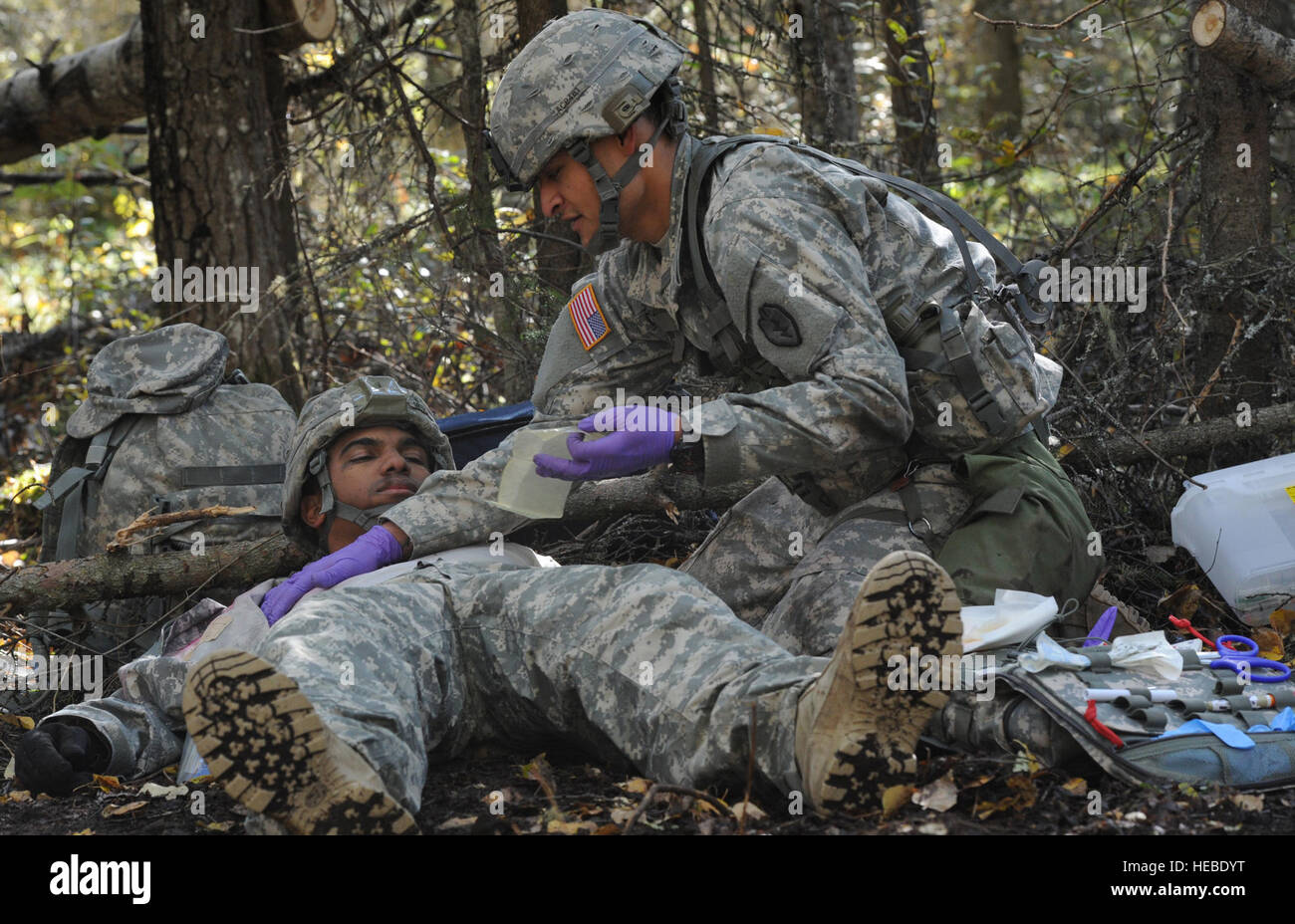 Army Spc. Adrian Castillo asignado al 2º Batallón, 8º Regimiento de Artillería de campo, parte del ejército de los EE.UU. Alaska's el primer equipo de combate de la Brigada Stryker, 25ª División de Infantería, un nativo de Buena Park, California, vendas 'herido' role-jugador Pfc del ejército. El alcalde Fidias Ortiz, asignado a la 725ª Brigada, Batallón de apoyo de parte del ejército de los EE.UU. Alaska's 4ª Brigada de infantería aerotransportada (equipo de combate), la 25ª División de Infantería, un nativo del Bronx, N.Y., mientras que las pruebas para el codiciado distintivo de médicos expertos de campo en base conjunta Elmendorf-Richardson, Alaska, el 20 de septiembre, 2013. (Ee.Uu. Foto de la fuerza aérea por Justin Connaher/liberado) Foto de stock
