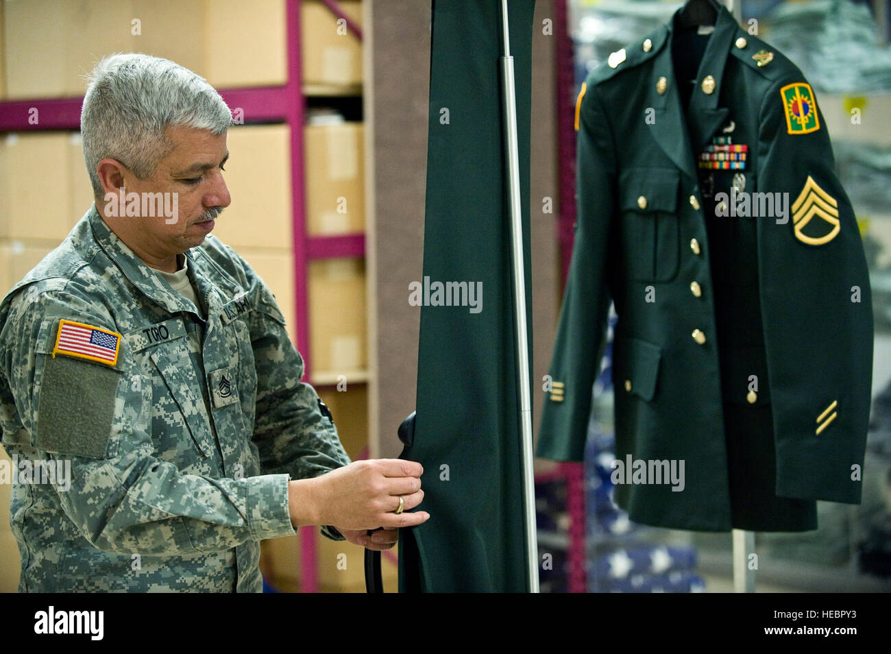 El sargento de primera clase del Ejército de los Estados Unidos Jimmy Toro,  un especialista en asuntos mortuorios, vapor limpia el uniforme de un  soldado caído durante la preparación de la transferencia